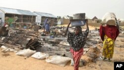 People walk through the debris at a camp for people displaced following an explosion by Islamist extremists, in Maiduguri, Nigeria, June 8, 2017.