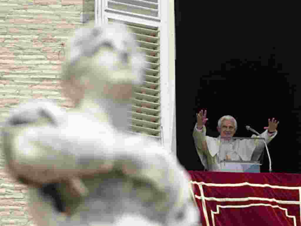 Pope Benedict XVI acknowledges the crowd during a prayer from his studio window overlooking St. Peter's Square at the Vatican, Sunday, May 15, 2011