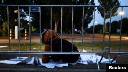 FILE: An asylum seeker waits outside at the main reception center for asylum seekers, in Ter Apel, Netherlands August 26, 2022.