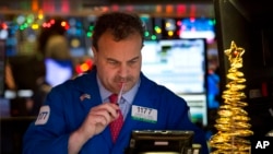 FILE - Gerard Farco follows stock prices at the New York Stock Exchange in New York, Dec. 21, 2016. 