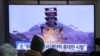 Ljudi gledaju preko televizije fotografi zemaljskog testa motora u Severnoj Koreji, na železničkoj stanici u Seulu, Južna Koreja, 9. decembra 2019.