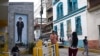 A man poses for a picture near a mural of Venezuelan Jose Gregorio Hernandez, known as the "Doctor of the Poor," after Pope Francis approved his canonization, making the doctor the nation's first saint, in Caracas, Venezuela, Feb. 25, 2025.