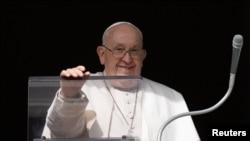 El papa Francisco sonríe desde una ventana del Vaticano durante el rezo del Ángelus el 14 de enero de 2024.