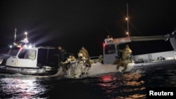 Sejumlah pelaut tampak menarik bagian dari balon mata-mata China di lepas pantai Myrtle Beach, di South Carolina, pada 5 Februari 2023. Balon tersebut akhirnya ditembak jatuh pada 4 Februari 2023. (Foto: U.S. Fleet Forces/U.S. Navy photo/Handout via Reuters)