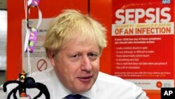 El primer ministro británico, Boris JOhnson, habla con personal del ala infantil del Hospital Universitario Milton Keynes, Inglaterra, el viernes 25 de octubre de 2019. (Toby Melville/Pool via AP)