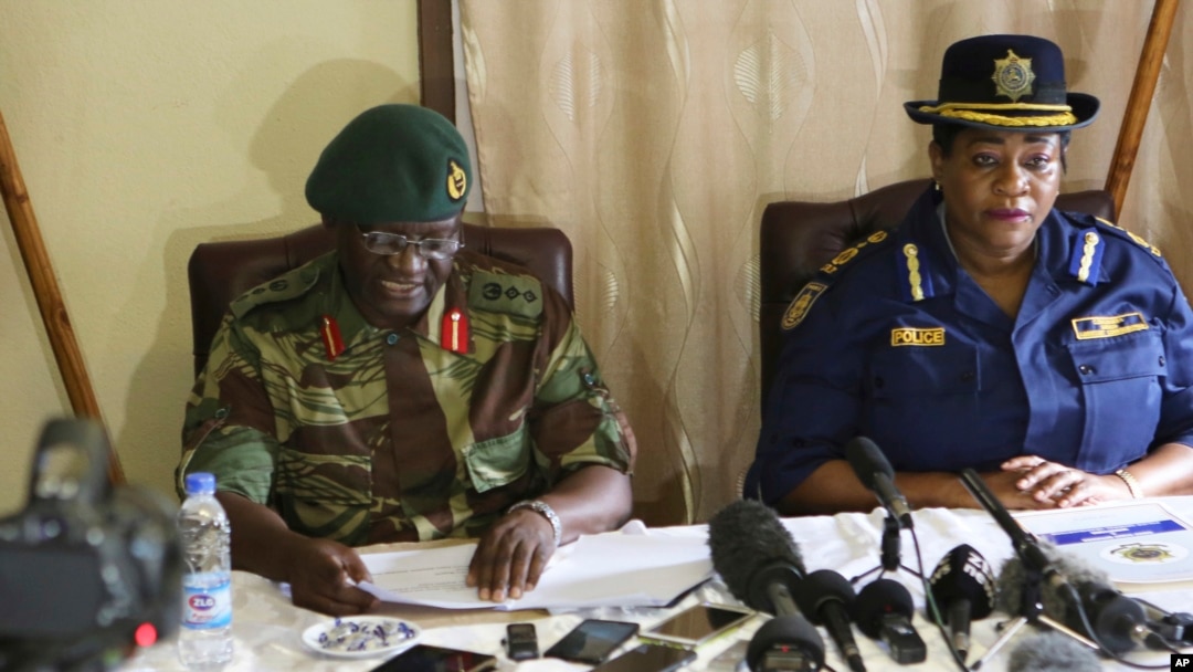 Zimbabwe army spokesperson Colonel Overson Mugwisi, left, addresses a press conference with police spokeswoman Charity Charamba, at Police General Headquarters in Harare, Zimbabwe, Nov. 27, 2017.