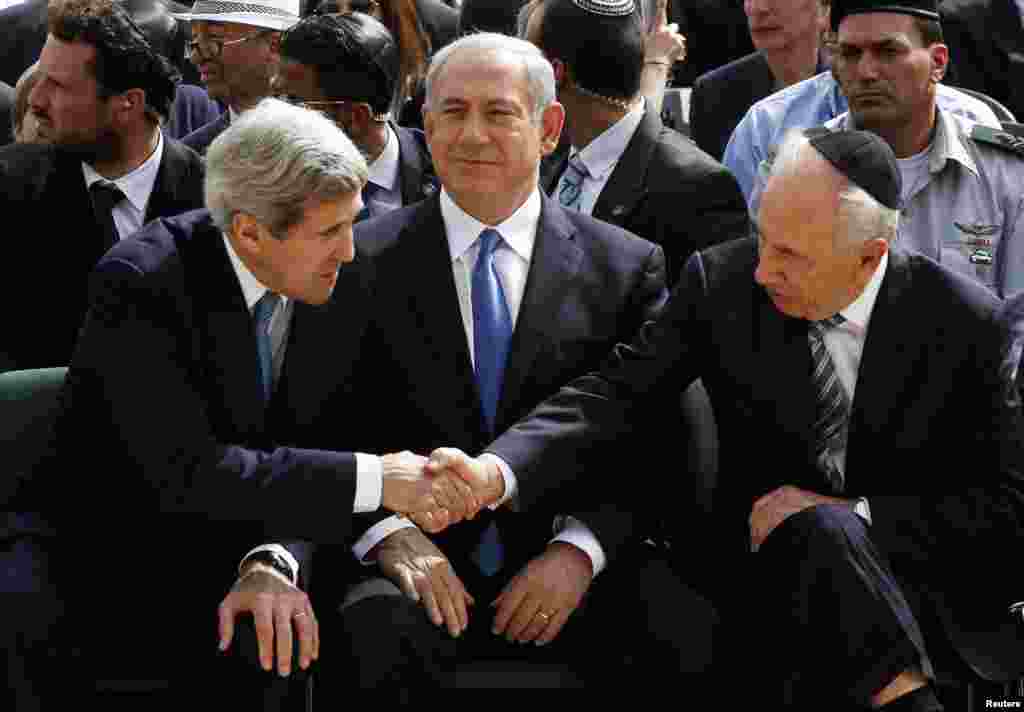U.S. Secretary of State John Kerry shakes hands with Israeli President Shimon Peres as Prime Minister Benjamin Netanyahu sits between at Yad Vashem, Jerusalem, April 8, 2013.