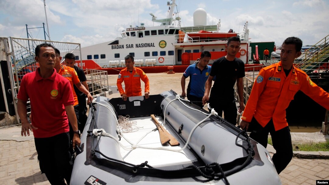 Tim SAR membawa kapal karet dengan KN Purworejo di belakang mereka, pada operasi pencarian pesawat AirAsia QZ8501 di Pangkalan Bun (6/1).