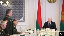 FILE - Belarusian President Alexander Lukashenko, right, attends a meeting with military top officials in Minsk, Belarus, Monday, Oct. 10, 2022.