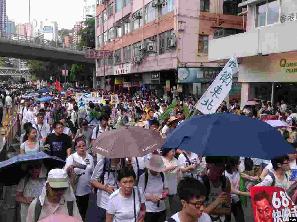 今天是香港回归17周年纪念日，在官方和亲北京团体举行各种庆祝活动的同时，几十万市民下午冒着高温走上街头，参加七一大游行(美国之音海彦拍摄)