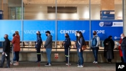 People queue at the Vaccination Center of Hope at the Cape Town International Convention Center in Cape Town, South Africa, Aug. 4, 2021.