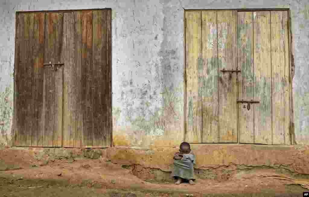 A young Ugandan boy sits outside the front of his house in the village of Kyanukuzi, near Masaka, in Uganda.