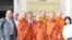 Thach Ngoc Thach, left and newly re-ordained monk Tim Sakhorn, middle, drops by VOA Khmer while on a visit in the US.
