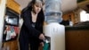 In a Dec. 9, 2010 photo, Roberta Walker draws bottled water at her home in Hinkley, California. The small community's struggles with contaminated groundwater inspired the award-winning Hollywood movie "Erin Brockovich."