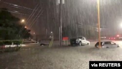 Vehicles are stuck in a flooded street as Tropical Storm Beta brings rain in Houston, Texas, Sept. 21, 2020, in this still image from video obtained via social media. (@PastorJaimeG via Reuters) 