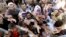 FILE - Displaced Iraqis from the Yazidi community gather for humanitarian aid at the Syria-Iraq border at Feeshkhabour border point, northern Iraq, Aug. 10, 2014.