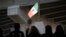 People attend a rally against a scheduled upcoming visit to the area by President Donald Trump as a flag fashioned after the flag of Mexico flies over Chicano Park, March 12, 2018, in San Diego. 