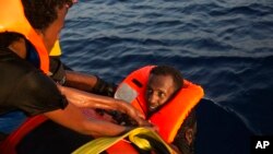 Un migrant d'Erythrée est récupéré de la mer après avoir sauté d'un bateau en bois bondé, à environ 13 milles au nord de Sabratha, Libye, 29 août 2016. 