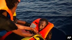 Un migrant en train d'être secouru après une chute dans l'eau de la Méditerranée à Sabratha, Libye, 29 août 2016