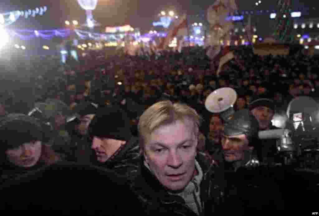 Oposition candidate Vitaly Rymashevsky, bottom, takes part in a rally in Minsk, Berlarus, early Monday, Dec. 20, 2010. Thousands of opposition supporters in Belarus tried to storm the main government building to protest what the opposition claims was larg