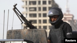 FILE - A policeman stands guard in Karachi, Pakistan, May 14, 2015. Police said Thursday that IS commander Kamran Aslam, also known as Kamran Gujjar, was killed in a raid in Karachi’s Ettihad Town neighborhood.