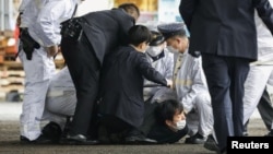 La police détient un homme soupçonné d'avoir jeté un objet explosif près du Premier ministre japonais Fumio Kishida au port de pêche de Saikazaki à Wakayama, dans le sud-ouest du Japon, le 15 avril 2023.