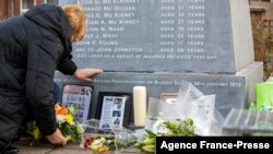 Flowers are picture placed at a memorial engraved with the names of the 13 who died during the 1972 Bloody Sunday killings, and John Johnston who died later, in the Bogside area of Londonderry, (Derry) in Northern Ireland on Jan. 29, 2022,