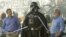 El presidente y CEO de Disney, Bob Iger, izquierda, y el creador de Star Wars, George Lucas, juegan con el personaje de Darth Vader. Disney compró los estudios LucasFilm. 