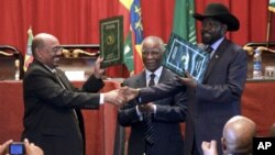 Sudan's President Omar al-Bashir, left, and South Sudan President Salva Kiir, right, shake hands on the completion of a signing ceremony after the two countries reached a deal on economic and security agreements in Addis Ababa, Ethiopia, Sept. 27, 2012. 