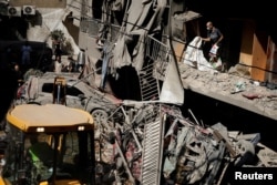 Orang-orang memeriksa lokasi serangan udara Israel, di tengah permusuhan yang sedang berlangsung antara Hizbullah dan pasukan Israel, di Beirut, Lebanon, 11 Oktober 2024. (Foto: Louisa Gouliamaki/REUTERS)