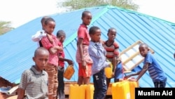 Children are filling their water containers at the makeshift Camp for Yemeni refugees near the Somali capital Mogadishu. (Courtesy of Muslim Aid)