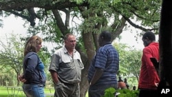 Gary Stafford and his wife talk to the Director General of National Parks, Vitalis Chadenga, after their bird sanctuary Kuimba Shiri Safari Lodge was besieged by scores of Zanu PF supporters demanding they leave, on Lake Chibero, Zimbabwe, January 22, 201