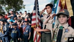 FILE - Boy Scouts and Cub Scouts salute the flag during ceremonies at the Los Angeles National Cemetery in Los Angeles on May 26, 2018.
