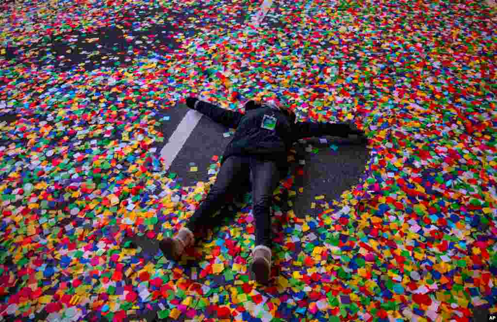 Jaclyn Bernstein, of New York, lies in confetti after the Times Square New Year's Eve Ball dropped in Times Square, early Jan. 1, 2021, in New York.