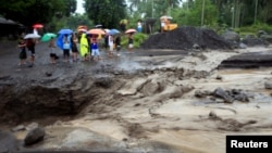 Para warga menyaksikan aliran banjir lahar dari abu vulkanis letusan Gunung Mayon di Guinobatan, Provinsi Albay, selatan Manila, Filipina, 27 Januari, 2018. 