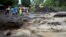 Residents watch a river of lahar, or or mud carrying volcanic debris, flow from Mount Mayon volcano in Guinobatan, Albay province, south of Manila, Philippines, Jan. 27, 2018. 