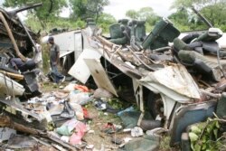 FILE - People mill around the accident site where an out-of-control bus that rolled several times and broke in two killed at least 30 people near Bafia, around 85 miles (135 kilometres) north of Yaounde, May 30, 2010.