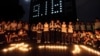 FILE - Students hold candles outside their dormitory during a ceremony to mark the anniversary of Japan's invasion of China in Zhuji, Zhejiang province, Sept. 17, 2013.