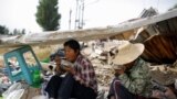 Migrant workers Wang Qin (L) and her sister Wang Jun eat lunch during a break from collecting scrap materials from the debris of demolished buildings at the outskirts of Beijing, China October 1, 2017.