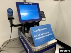 Sebuah pengumuman yang meminta konsumen menggunakan mesin kasir lain diletakkan di depan mesin kasir yang mengalami gangguan siber di sebuah supermarket di Brisbane, Australia, Jumat, 19 Juli 2024. (Foto: AAPImage/Jon Searle via Reuters)