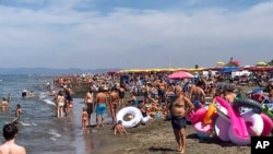 People enjoy the beach in Fregene, a fashionable sea resort some 30km (19 miles) north of Rome, July 26, 2020. 