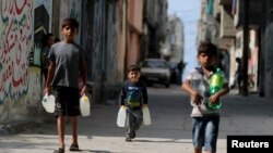 Palestinian boys carry bottles of water in Al-Shati refugee camp in Gaza City, Oct. 23, 2019. 