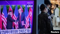 资料照片：一名韩国士兵站在韩国首尔一个火车站的一台电视机旁，屏幕上正播放关于朝鲜领导人金正恩与美国总统唐纳德·特朗普可能举行峰会的新闻报道。(2025年10月22日)
