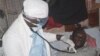 A health worker examines a man suffering from Ebola at a treatment centre in Monrovia, Liberia, Wednesday, Oct. 15, 2014. 