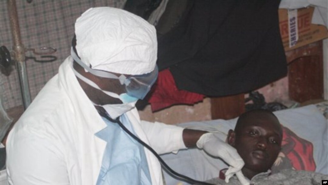 A health worker examines a man suffering from Ebola at a treatment center in Monrovia, Liberia, Oct. 15, 2014. 