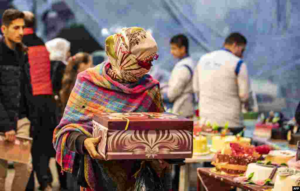 شام کے شمالی شہر قمیشی میں ایک خاتون نئے سال کی آمد کے موقع پر کیک خرید رہی ہیں۔ قمیشی میں زیادہ تر کردوں کی اکثریت ہے &nbsp;