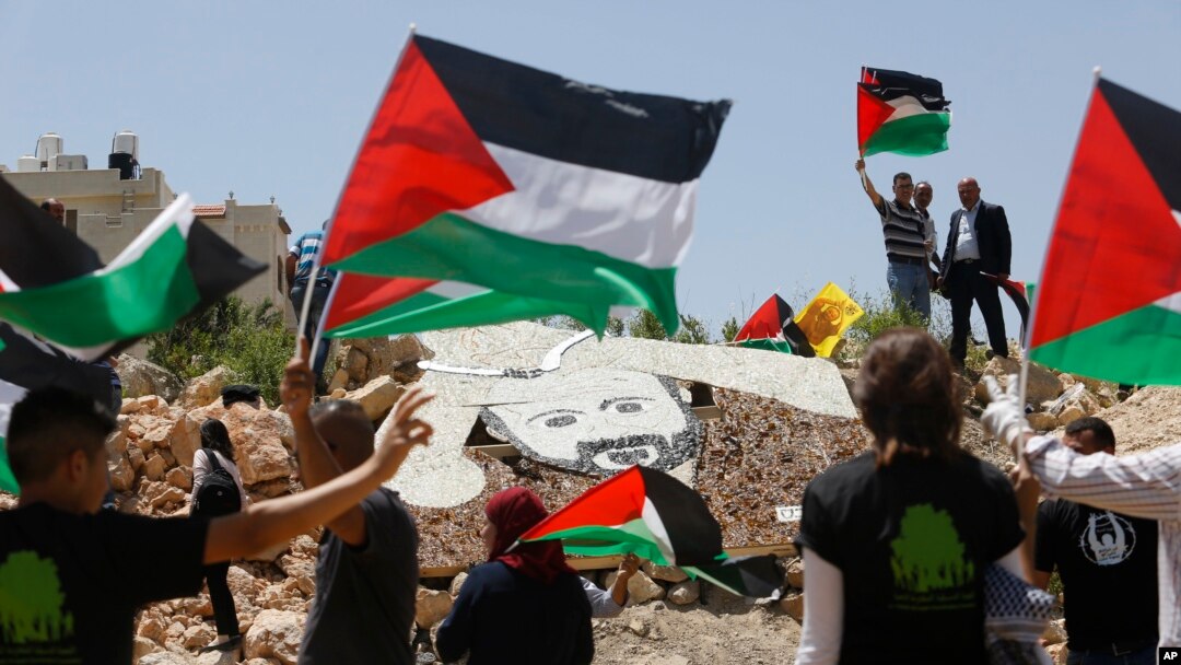 Para aktivis Palestina berdema dekat instalasi militer Israel di Kota Ramallah, Tepi Barat, 9 Mei 2017.