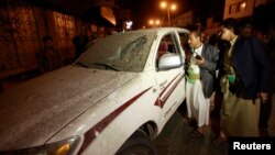 Police officers look at a damaged vehicle at the site of an explosion, near former President Ali Abdullah Saleh's house which is also within close proximity to the French embassy, in Sana'a, Feb. 3, 2014.