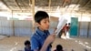 FILE PHOTO: A child reads a book in a makeshift school run by Rohingya teachers in Kutupalong refugee camp in Cox’s Bazar, Bangladesh, Feb. 7, 2019