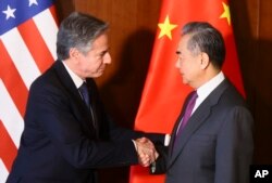 Menteri Luar Negeri AS Antony Blinken, kiri, dan Menteri Luar Negeri China Wang Yi berjabat tangan saat pertemuan di Konferensi Keamanan Munich, Jerman, Jumat, 16 Februari 2024. (Wolfgang Rattay via AP)